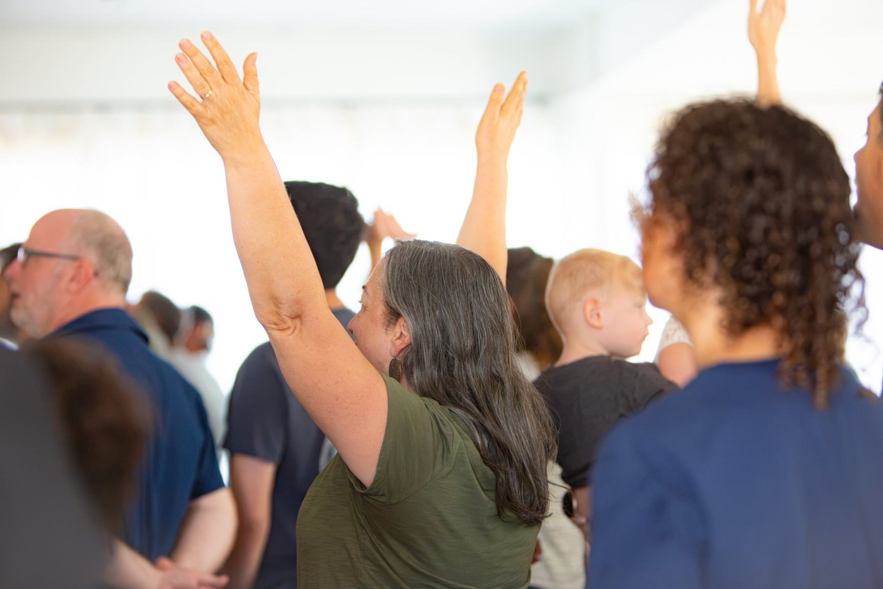 A room worshiping with hands lifted
